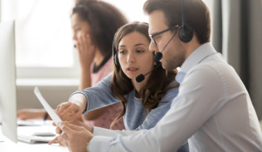 Woman discussing papers to a man.